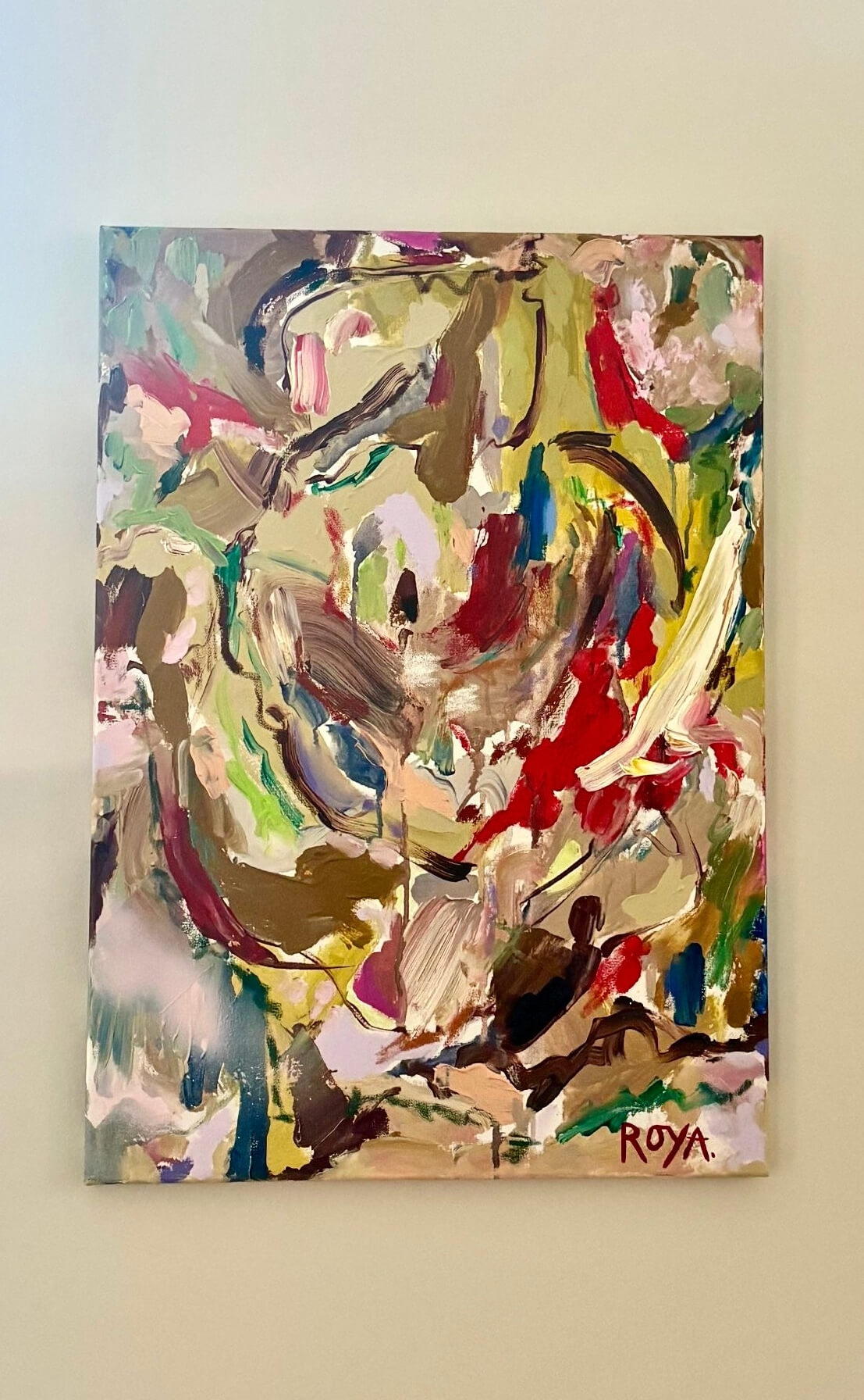 Abstract painting with vibrant colors on a beige wall