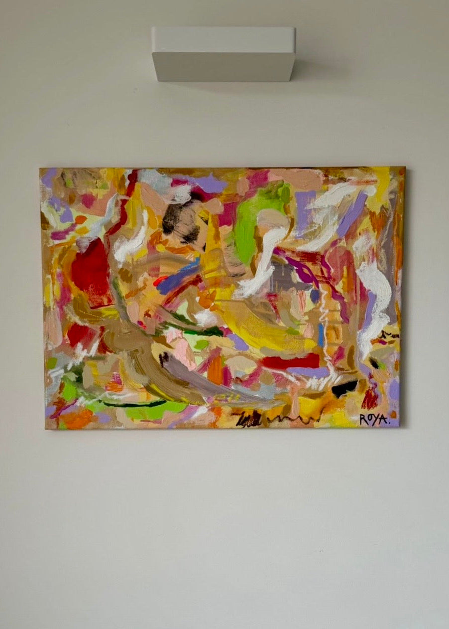 Colorful abstract painting on a white wall above a sofa