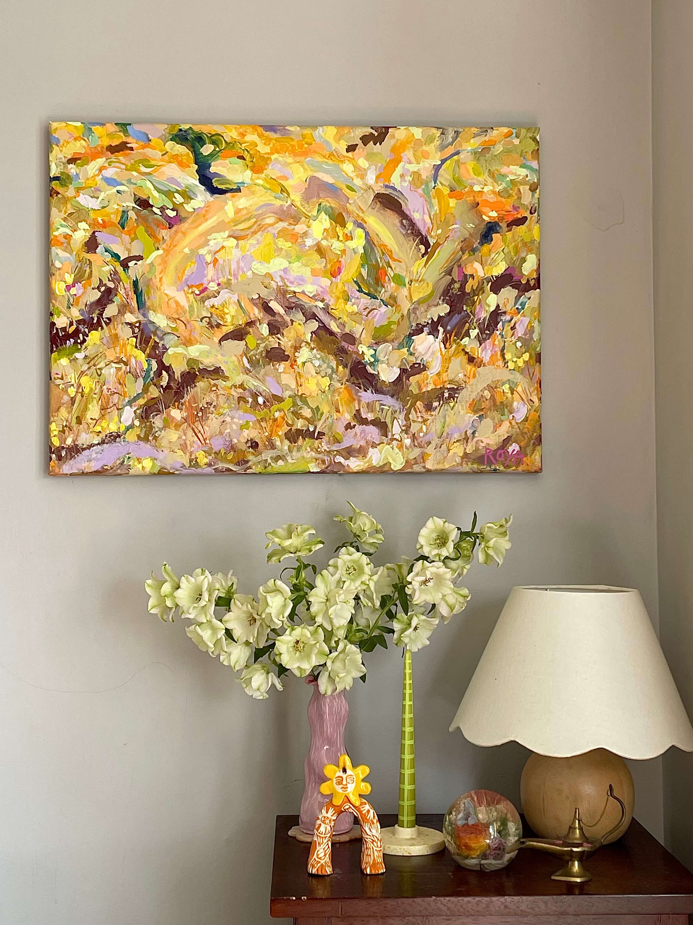 Abstract painting on a wall above a table with decorative items.