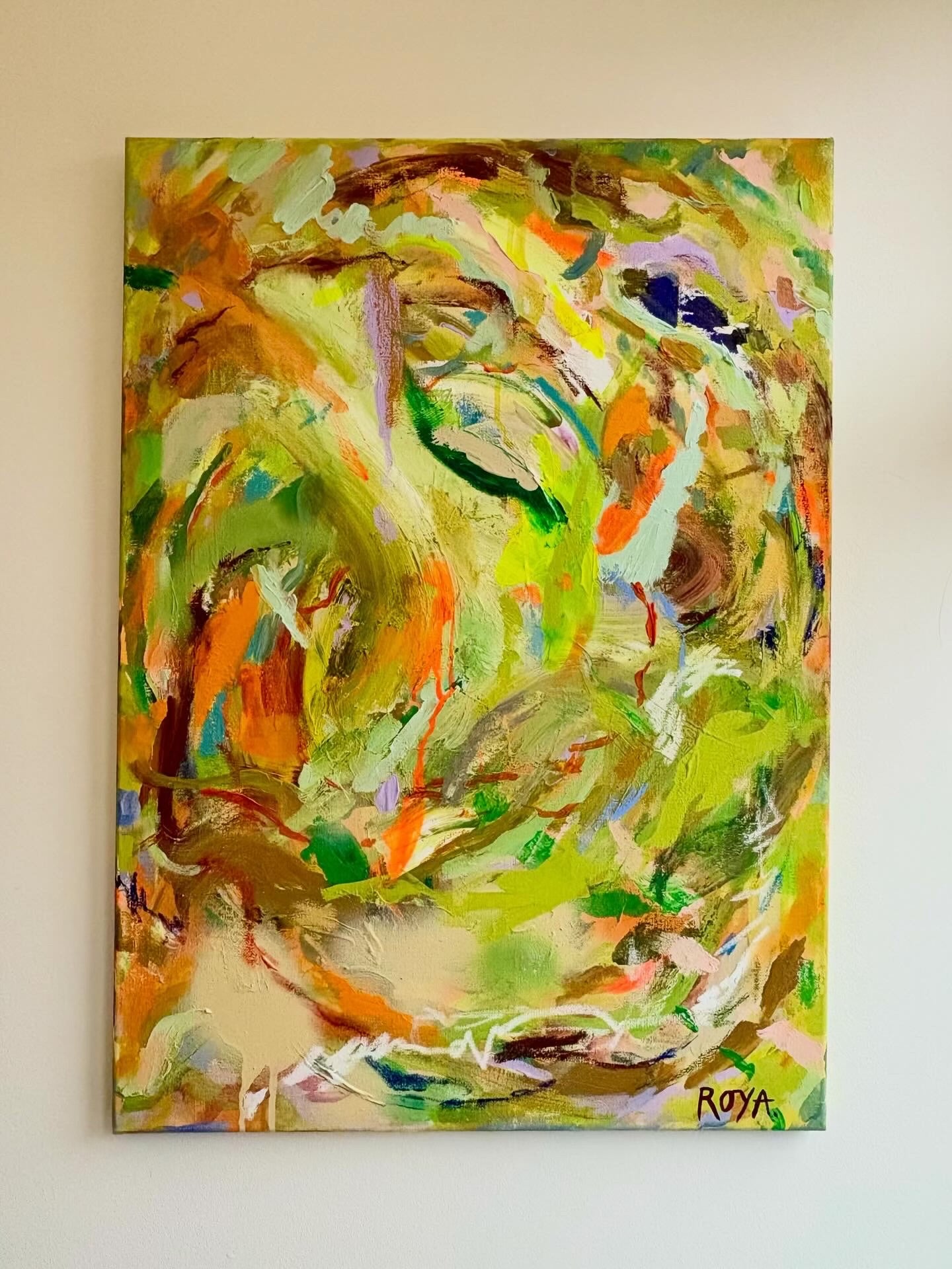 Abstract painting with vibrant colors on a beige wall