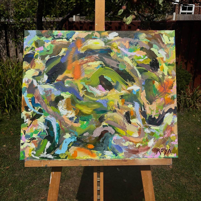Colorful abstract painting on an easel outdoors