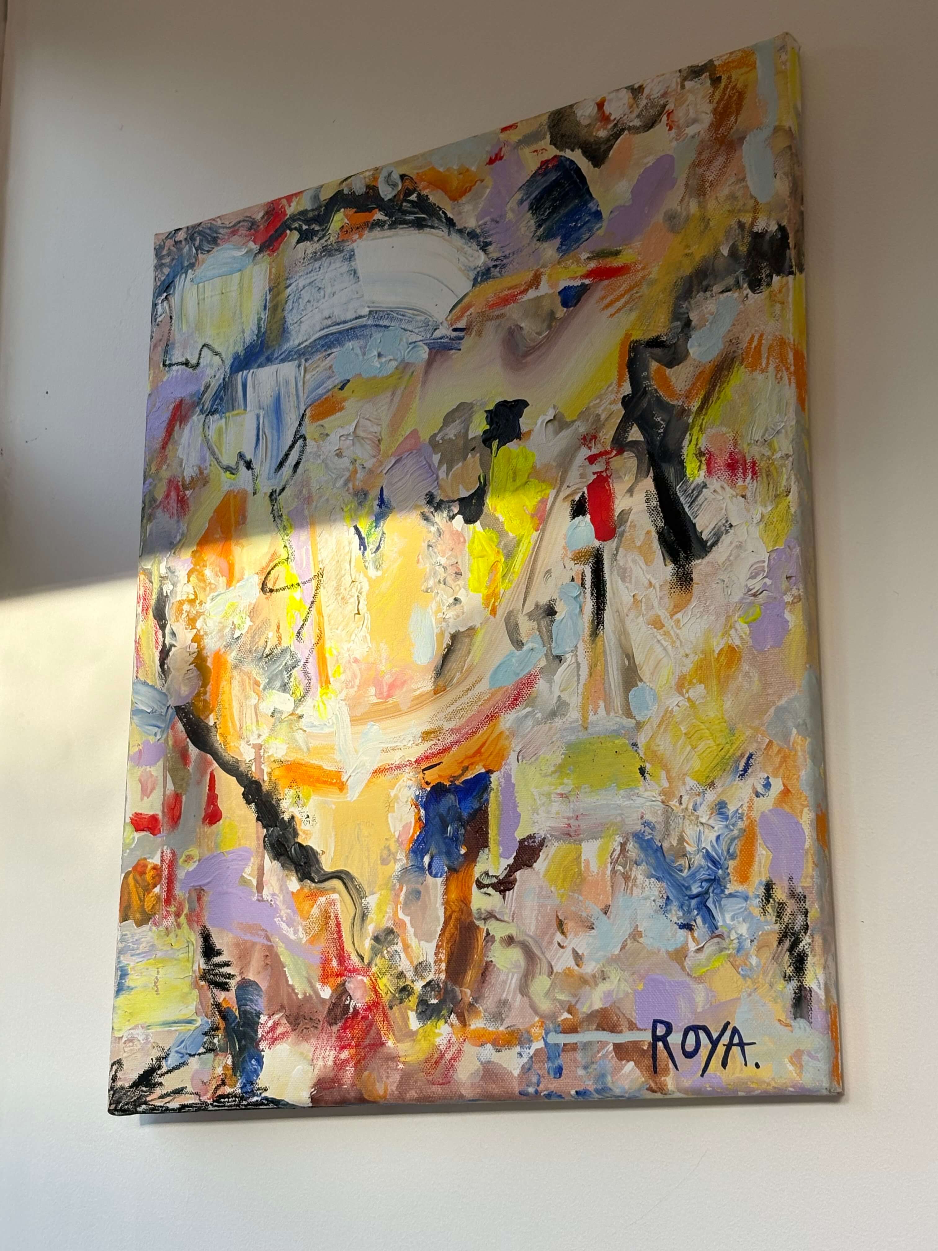 Abstract painting with vibrant colors on a white wall, signed 'ROYA'.